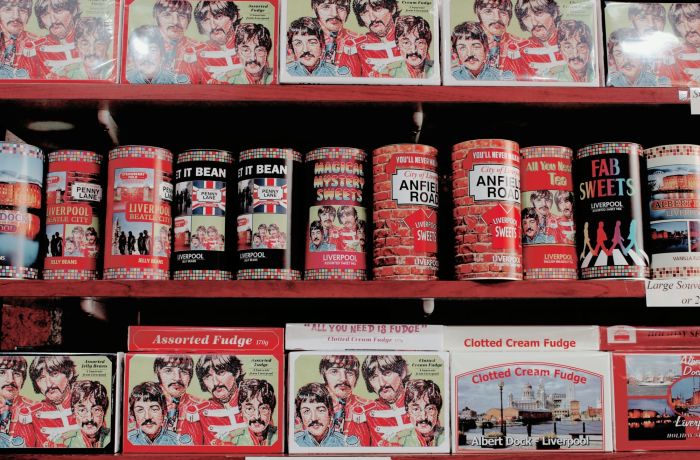 shelves with souvenir tins of sweets and boxes of fudge with the beatles images on