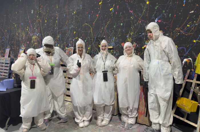 Guests in suits in the neon canvas painting room