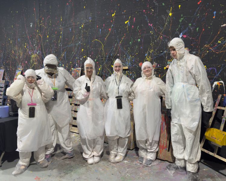 Guests in suits in the neon canvas painting room