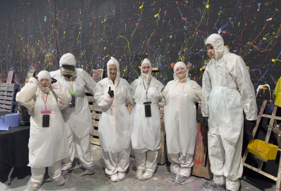 Guests in suits in the neon canvas painting room