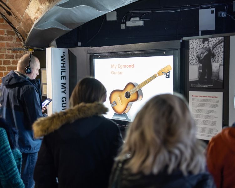 visitors looking at displays at the beatles story museum in liverpool