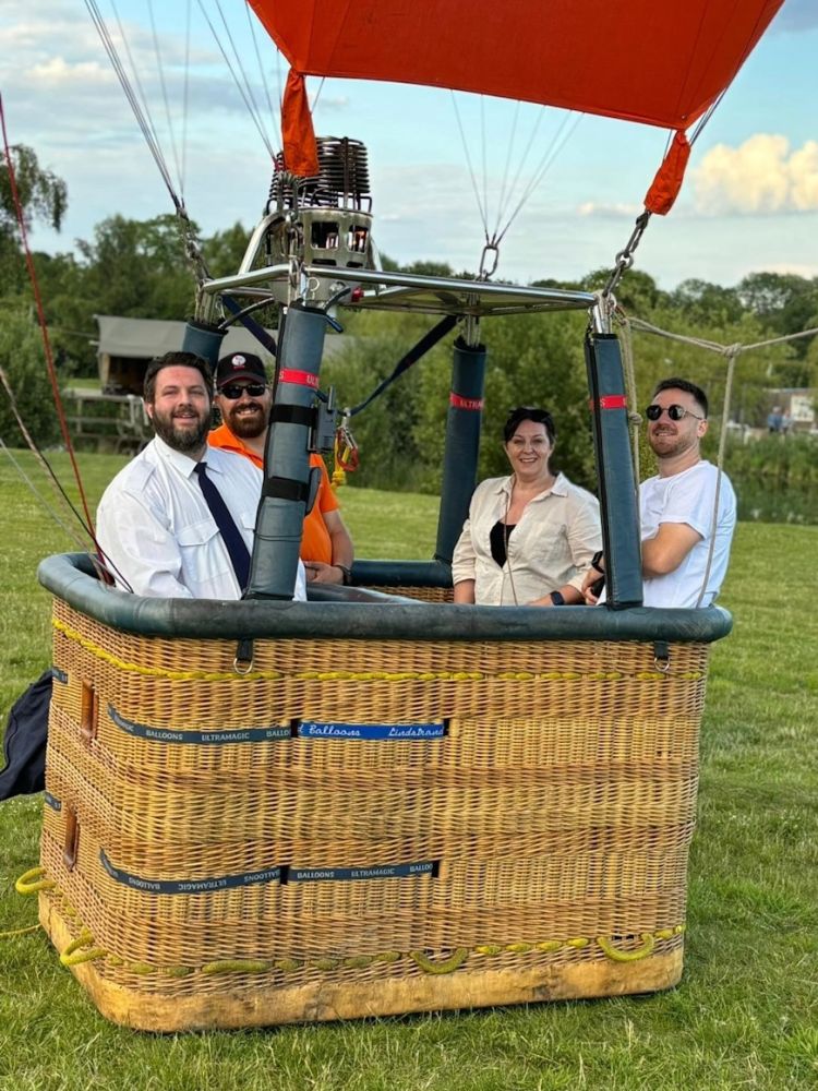 three people in a balloon basket ready for flight