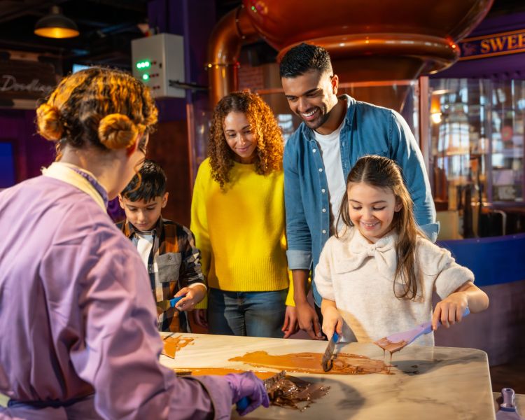 family having a go at chocolate tempering at cadbury world