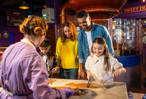 family having a go at chocolate tempering at cadbury world