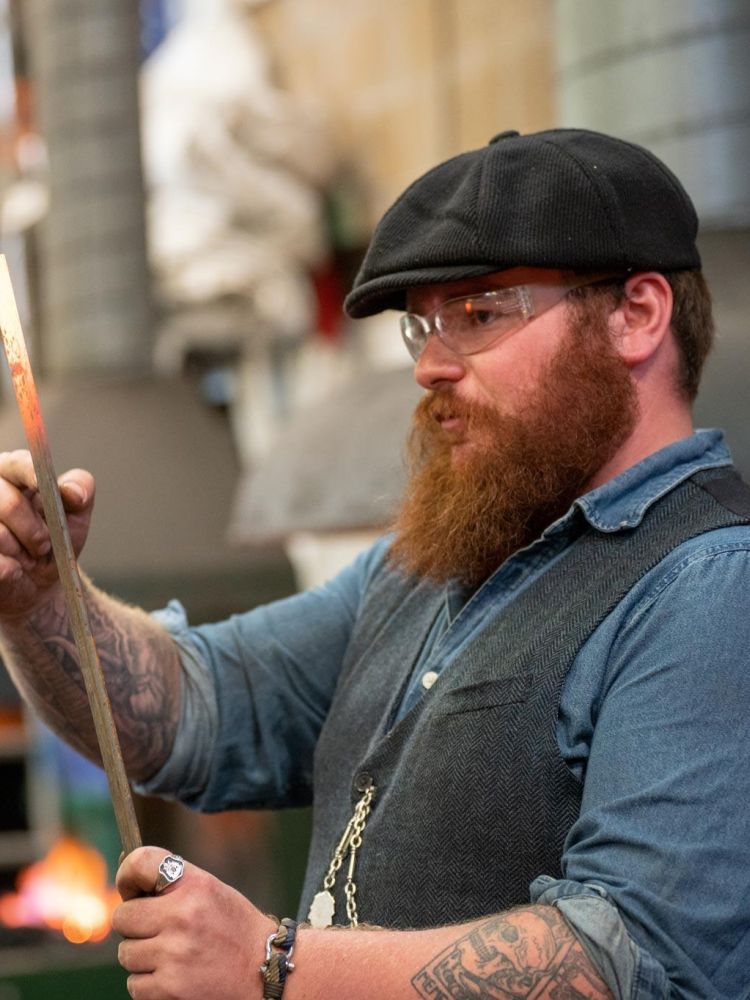 blacksmith demonstrating techniques to participants on a blacksmith experience