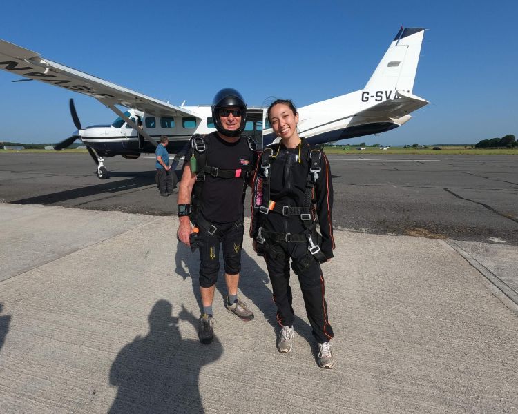 skydivers posing for photo on airfield in front of plane