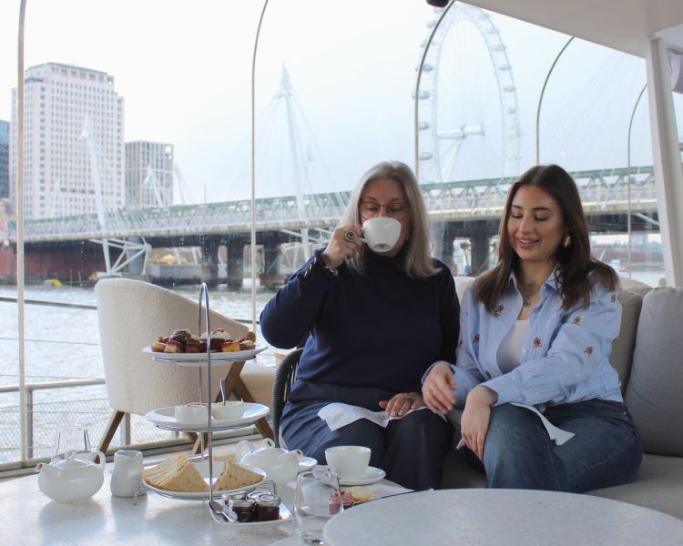 mum drinking tea at afternoon tea with daughter at clipper lounge london
