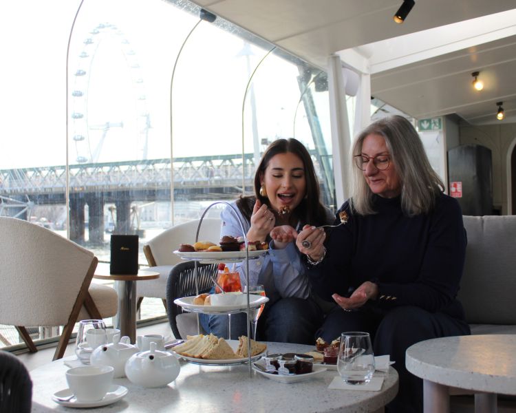 mum and daughter eating cake at afternoon tea at clipper lounge london