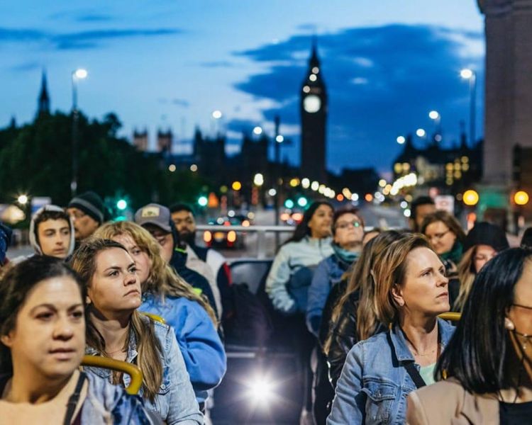 people on top deck of the london by night sightseeing bus tour