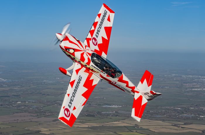 red and white aircraft at an angle in the sky for an extreme acrobatic flying experience