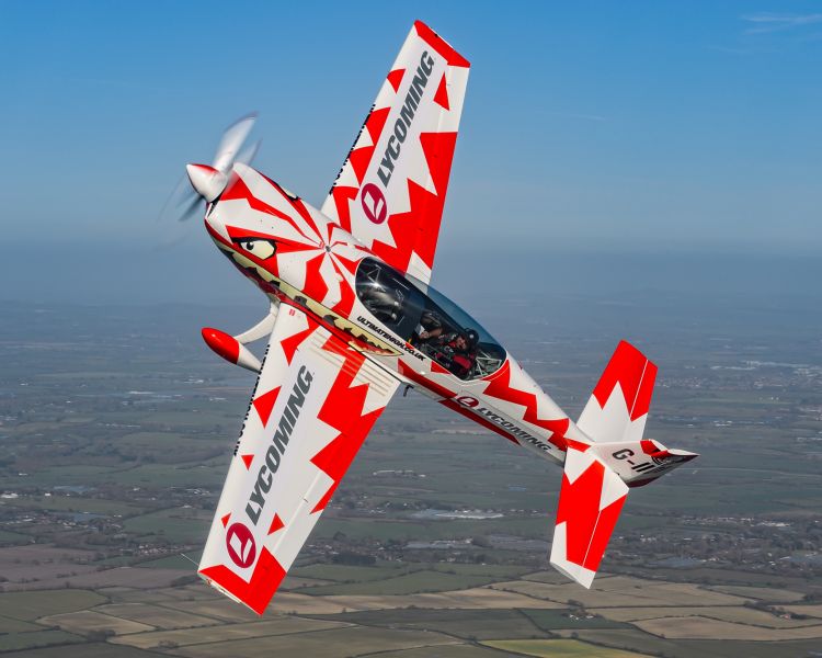 red and white aircraft at an angle in the sky for an extreme acrobatic flying experience