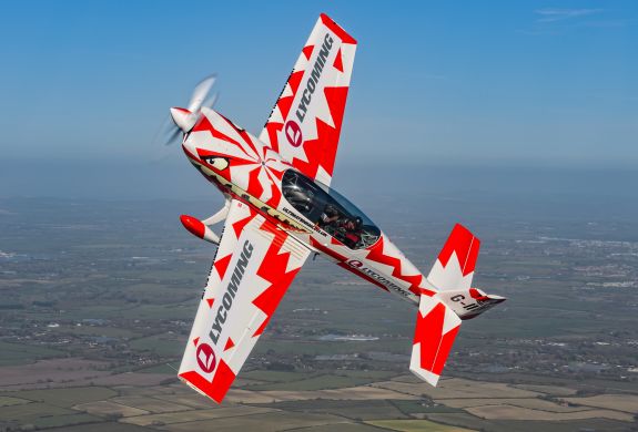 red and white aircraft at an angle in the sky for an extreme acrobatic flying experience