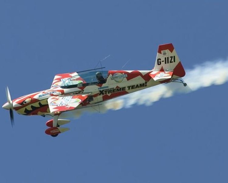 red and white plane flying through sky on aerobatic flying experience