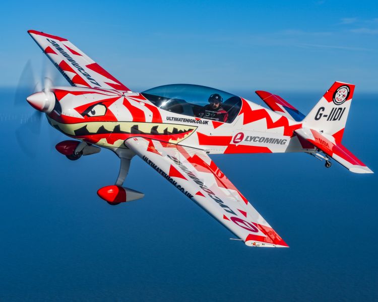 red and white aircraft at an angle in the sky for an extreme acrobatic flying experience