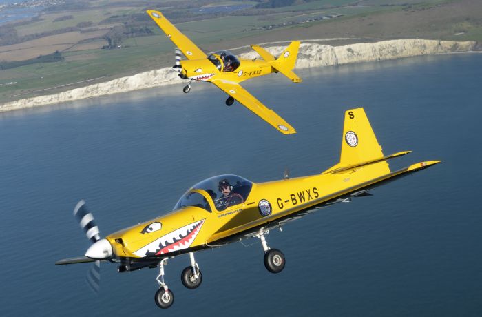 two yellow planes flying over coast on top gun flying experience