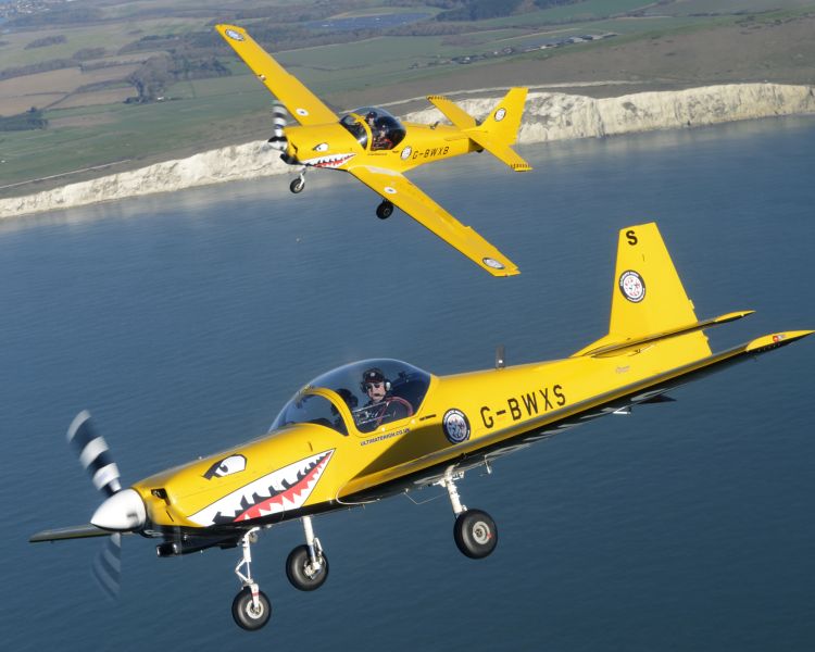 two yellow planes flying over coast on top gun flying experience