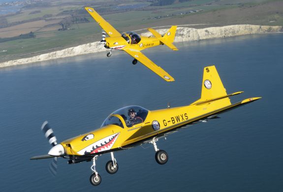 two yellow planes flying over coast on top gun flying experience