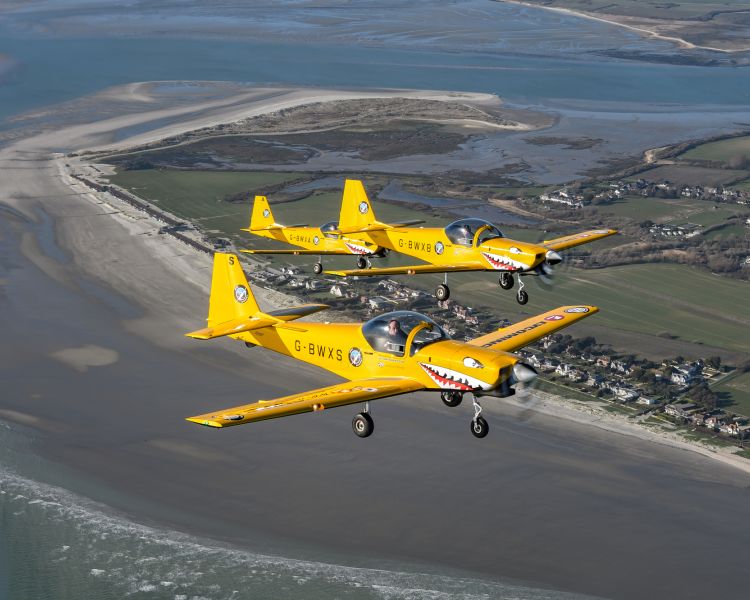two planes flying in formation over coastline on top gun flying experience