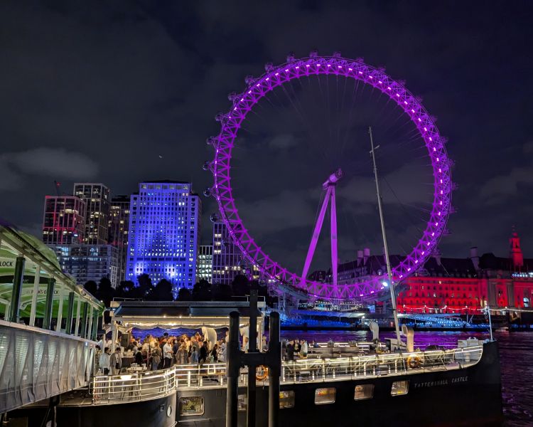 the tattershall castle boat on river thames at night with london eye lit up in pink behind it