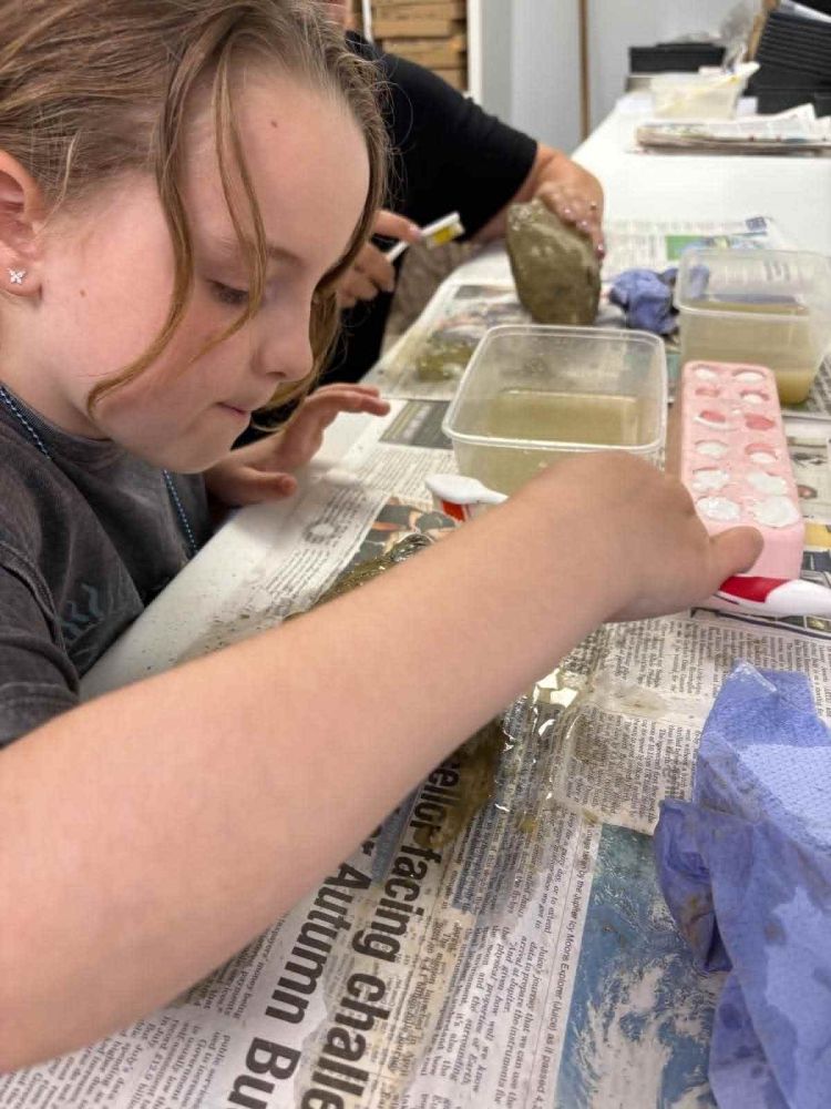 girl cleaning fossil on a young palaeontologist fossil experience at exotic zoo telford