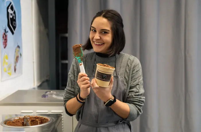 woman smiling and holding a tub of gelato on a learn how to make gelato workshop in london