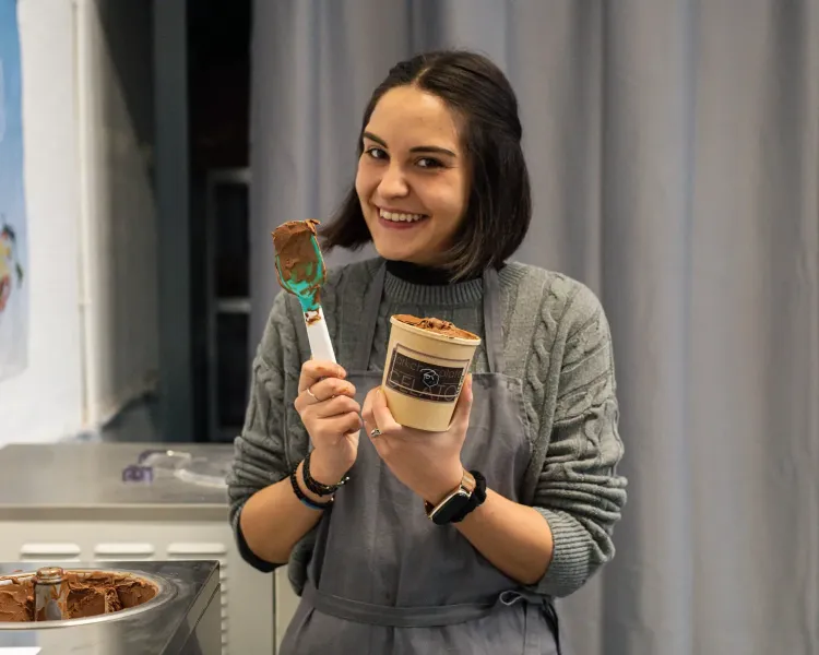 woman smiling and holding a tub of gelato on a learn how to make gelato workshop in london