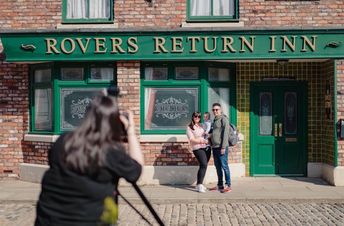 A family poses outside the Rovers Return