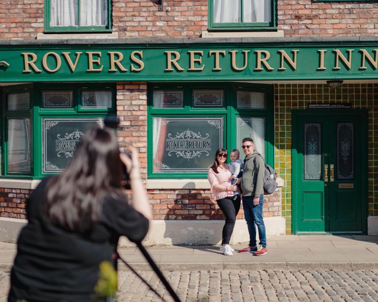 A family poses outside the Rovers Return