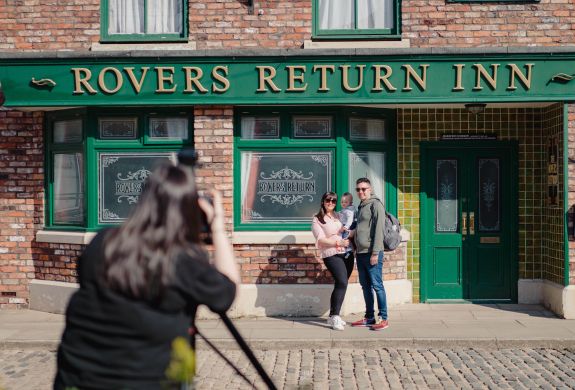 A family poses outside the Rovers Return