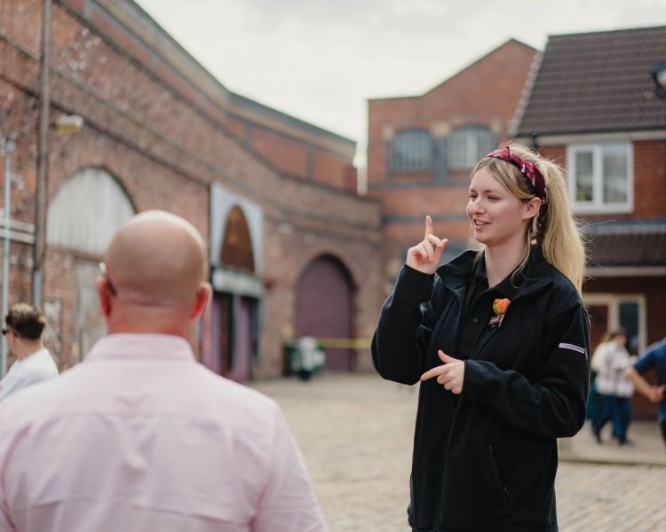 A tour guide leads guests around Coronation Street