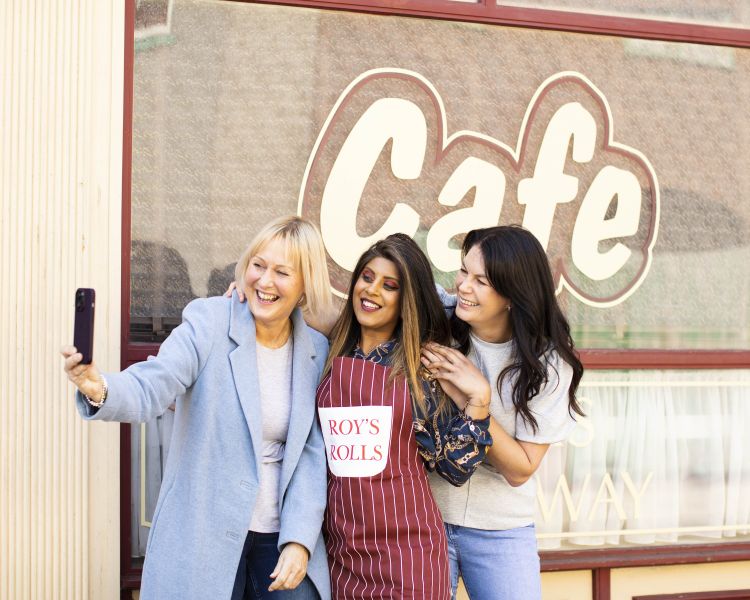 Friends pose outside Roys Rolls