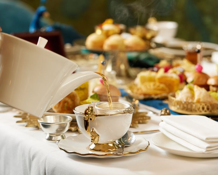 pouring tea at an indian jasmine afternoon tea at taj 51 buckingham gate suites and residences