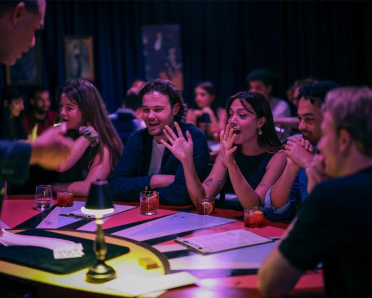 Surprised guests watching magician at the magicians table immersive show london