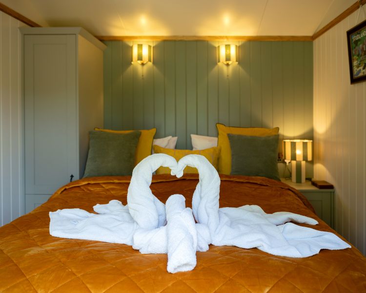 bedroom of ensuite shepherd hut at glamping site in dorset