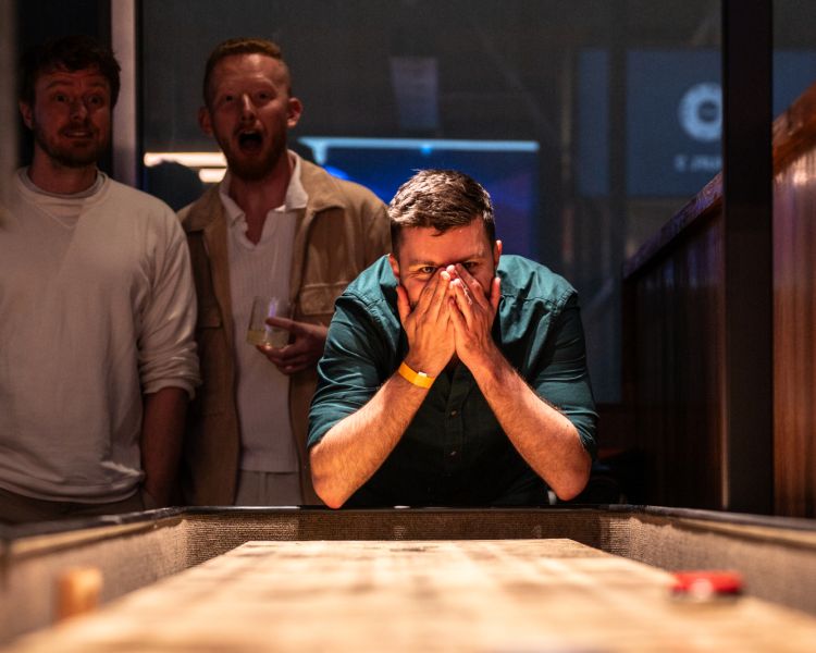 Men playing shuffleboard at the lucky goat