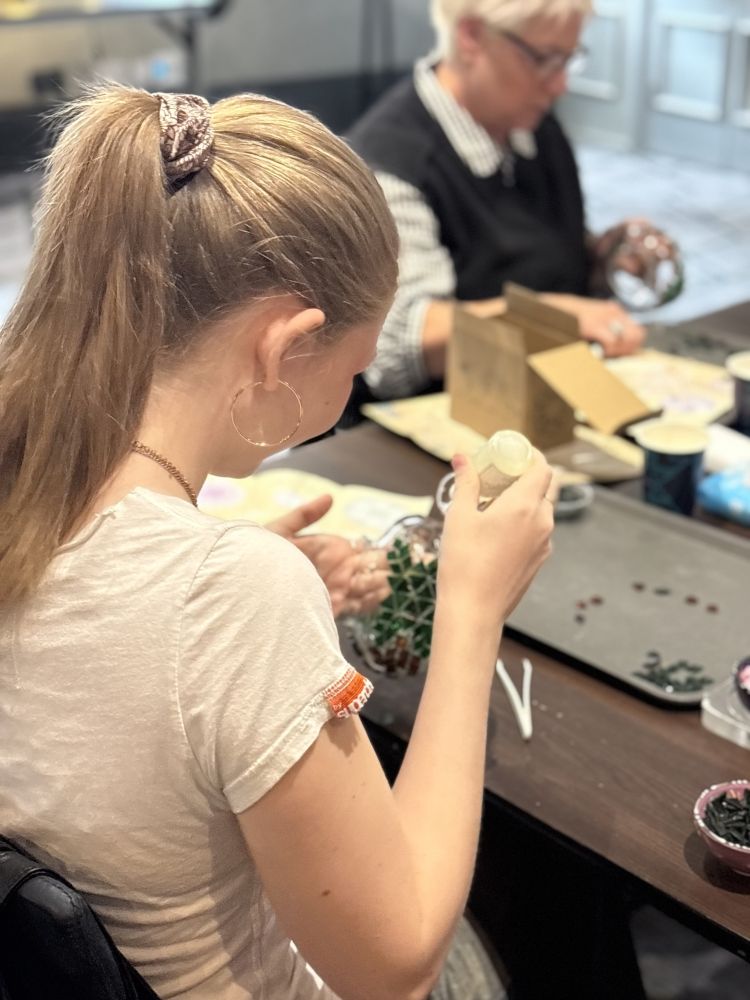 Ladies making mosaic glass candle holders