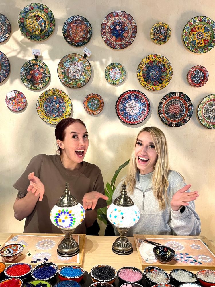 Two ladies with their turkish mosaic lamps decorated at workshop