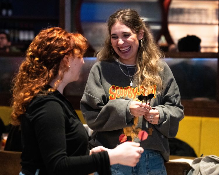 Two women playing darts at the lucky goat