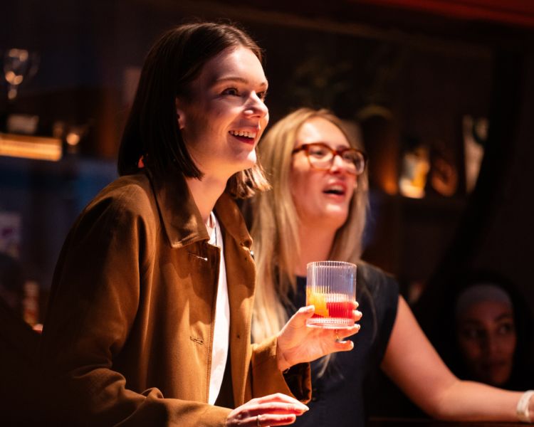 Two women playing shuffle board at the lucky goat