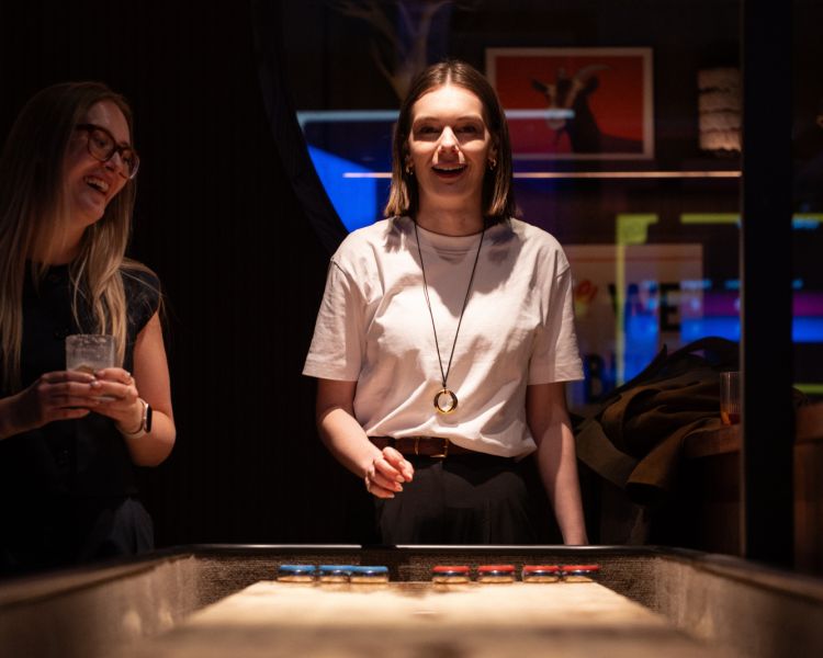 Woman playing shuffle board at the lucky goat