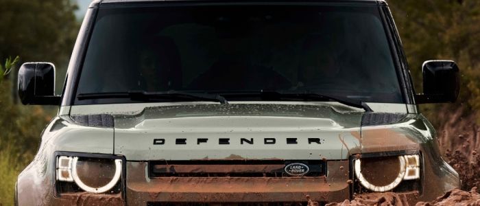 Land rover defender going through muddy water on driving experience