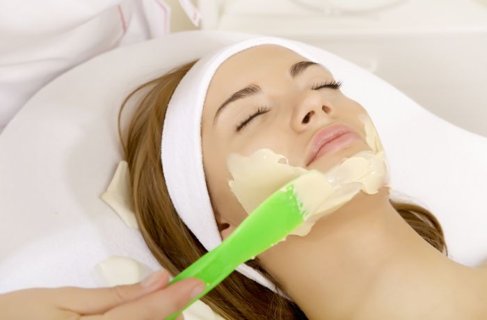 woman having face mask applied as part of beauty treatment