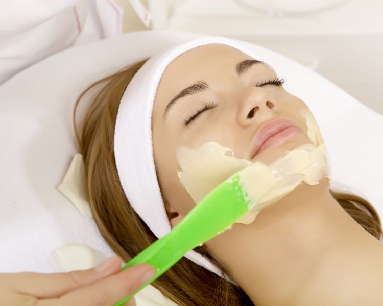 woman having face mask applied as part of beauty treatment