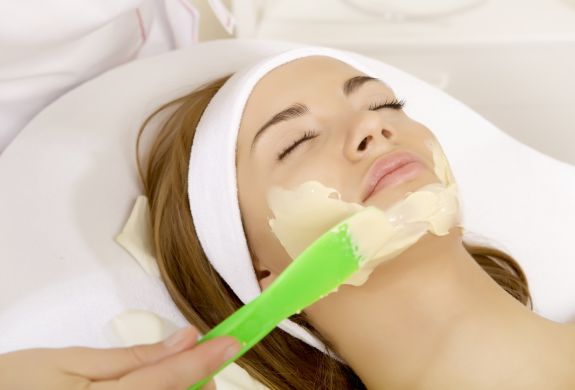 woman having face mask applied as part of beauty treatment