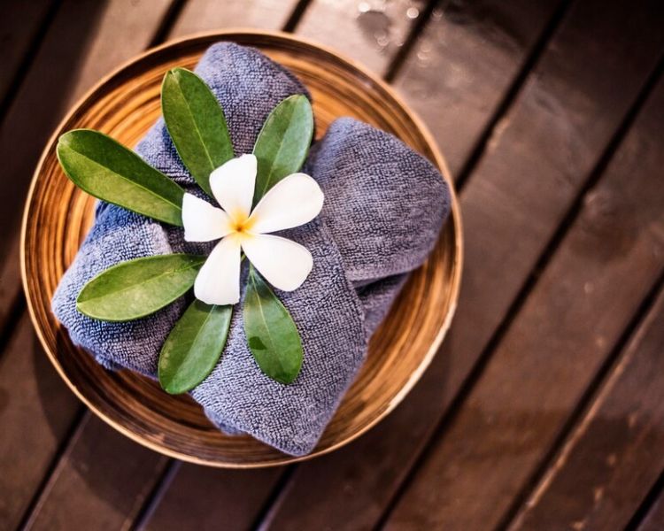 welcome towels at spa decorated with plumeria flowers