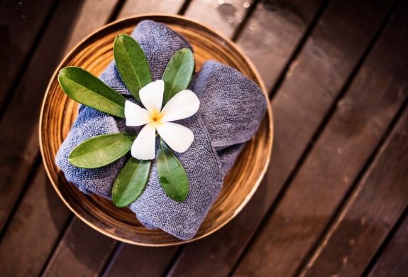 welcome towels at spa decorated with plumeria flowers
