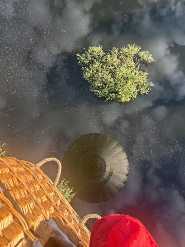 looking down over basket from private hot air balloon ride over water