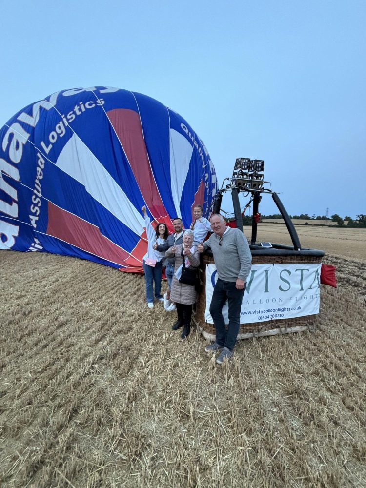 group photo with basket and balloon after landing from private hot air balloon ride over east midlands