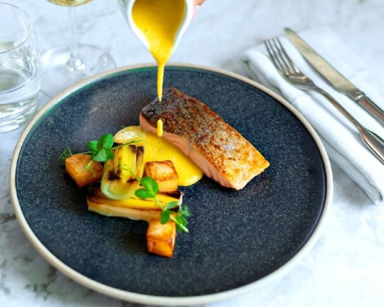 the salmon dish presented on a plate enjoyed on the gourmet six course bustronome london dinner experience