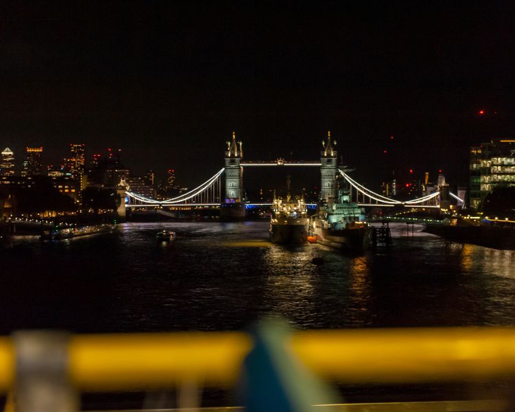 view from top deck of the london night bus tour of tower bridge lit up